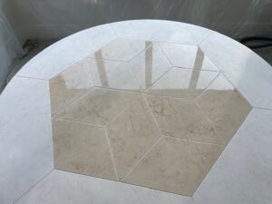 Overhead view of the center of a limestone table with fully cured AntiEtch®, highlighting the smooth, protective finish and preserved V-grooves.